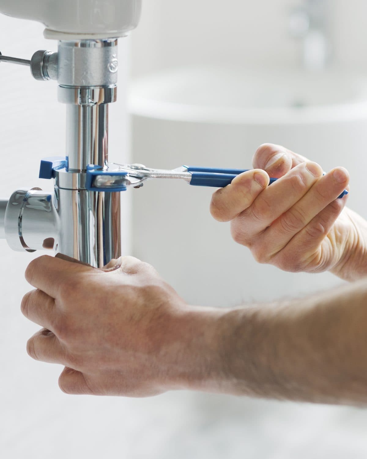 Siphon chromé resserré à la pince sous un lavabo